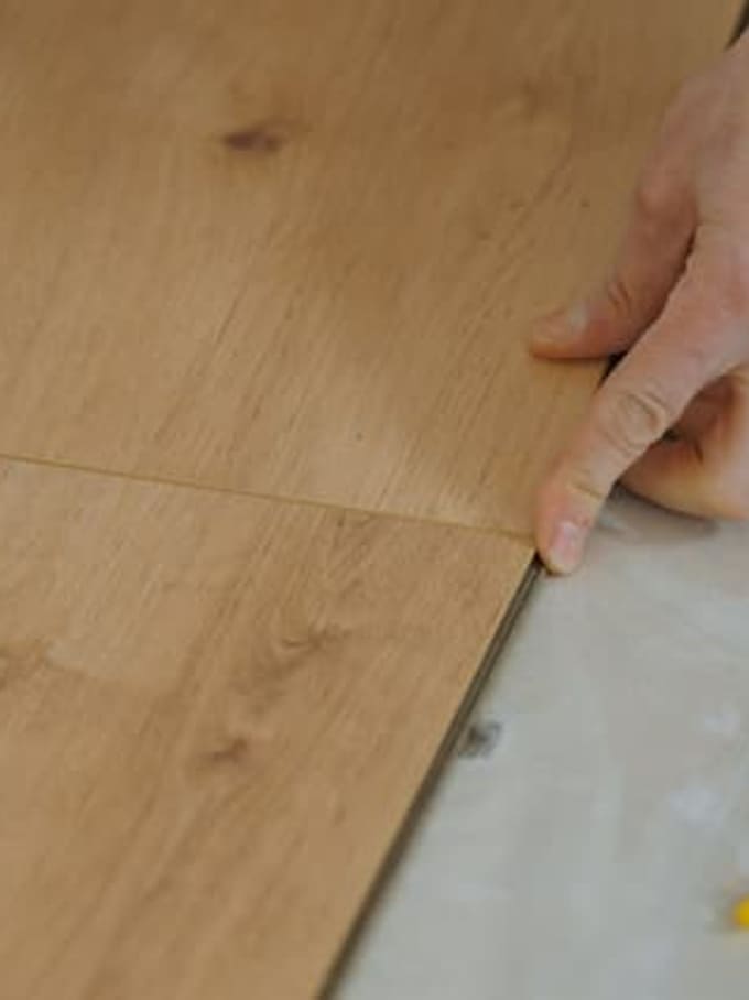 Eine Person klickt Bodenplatten ein