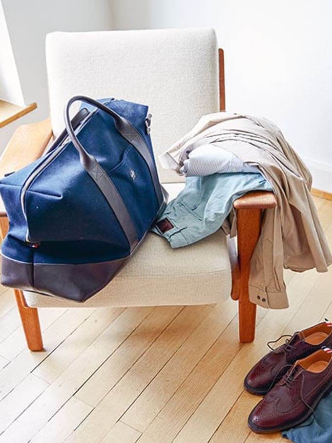 Kleider und eine Tasche auf einem Sessel