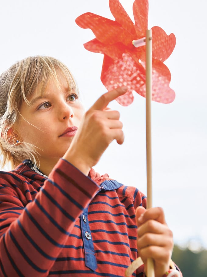 Image symbolisant l’adoption et la tutelle: une jeune fille a dans les mains un moulin à vent.