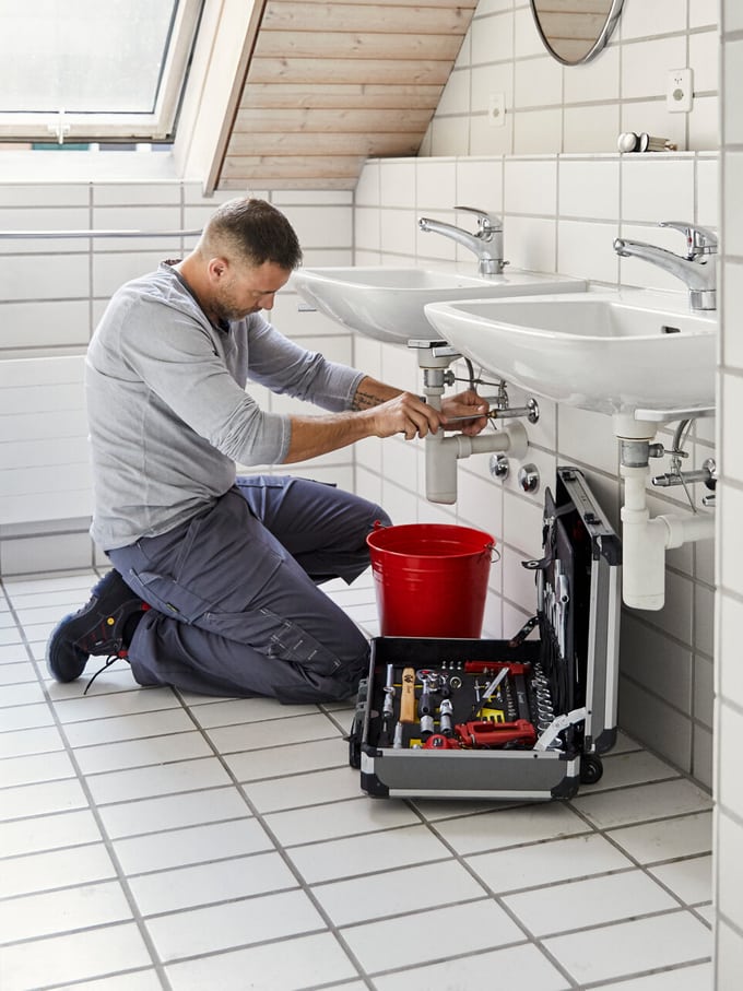sanitaer-repariert-abfluss-im-badezimmer