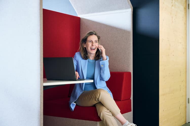 Eine Frau und ein Mann mittleren Alters stehen auf dem Trottoir einer Stadt in Joggingkleidung und blicken auf das Handydisplay der Frau. 