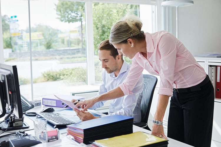 Un homme et une femme discutent à un bureau.