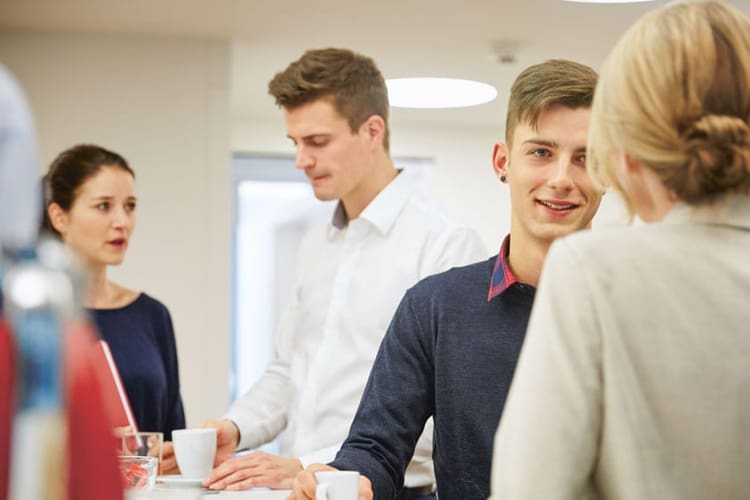 Quattro giovani discutono in un ufficio.