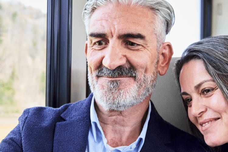 Frau und Mann sitzen in einem Zug und machen ein Selfie mit dem Smartphone.