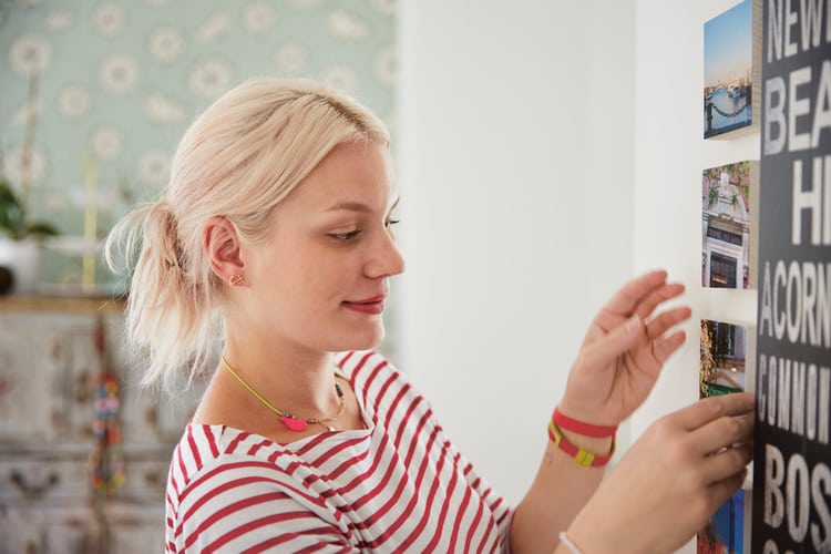 Femme sur le point d’accrocher des photos. 