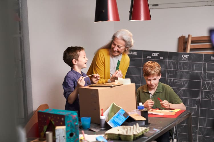 Ältere Frau mit Kinder am basteln