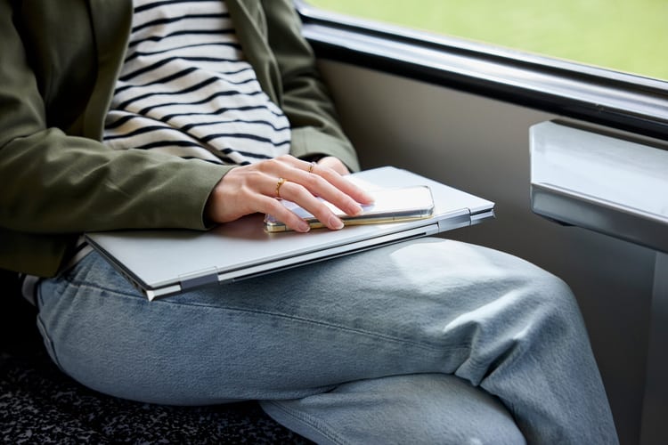 Une femme dans le train avec son ordinateur portable sur les genoux