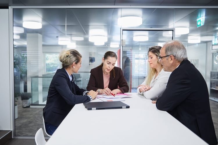 Besprechung von 4 Personen an einem hohen Tisch