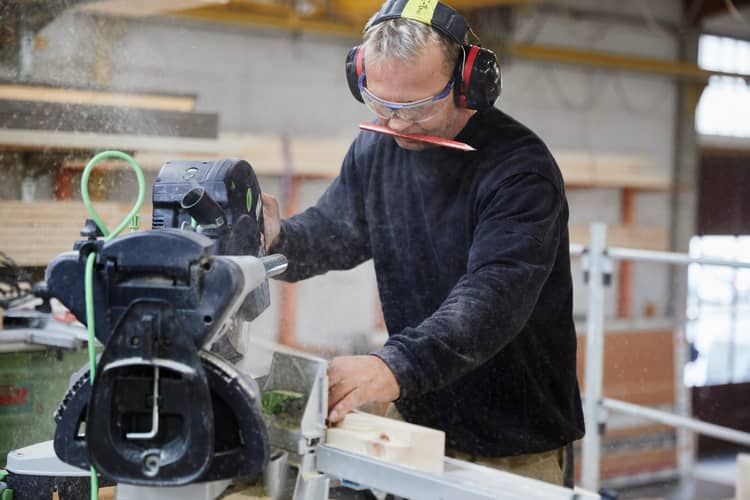 Ein Schreiner an einer Sägemaschine