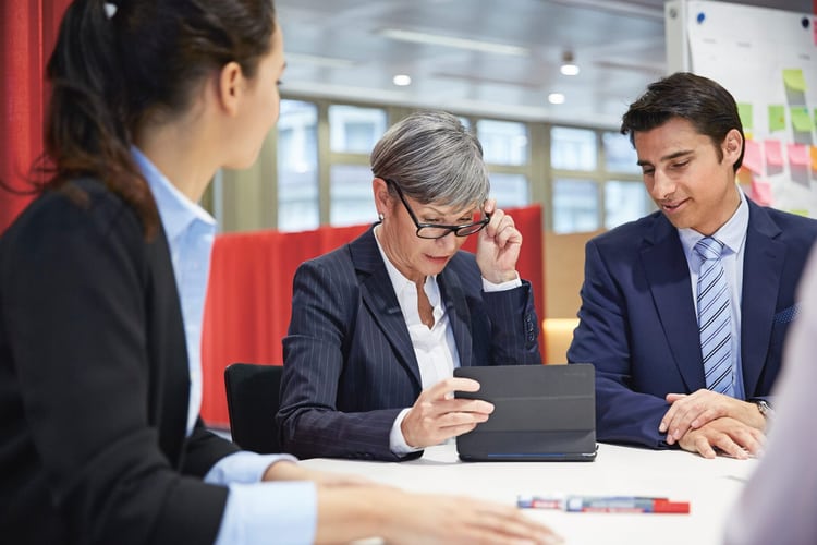 Drei Mitarbeiter besprechen etwas im Büro.