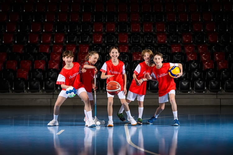 Eine Gruppe von jungen Sportlerinnen spielen Handball, Basketball, Unihockey und Volleyball