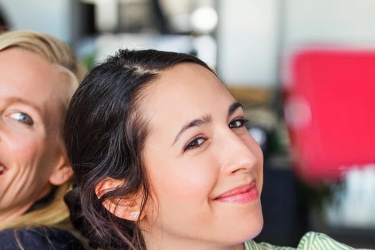 Deux femmes éclatent de rire et regardent une carte bonus.