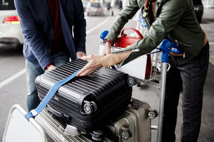 Valises sur un chariot à bagages à l’aéroport