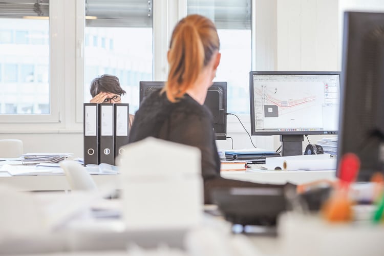 Eine Frau in einem Büro schaut auf den Bildschirm.
