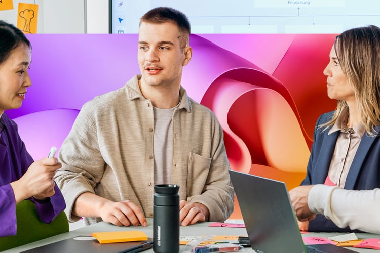Junge Mitarbeitende im Teamwork mit Laptop und Whiteboard