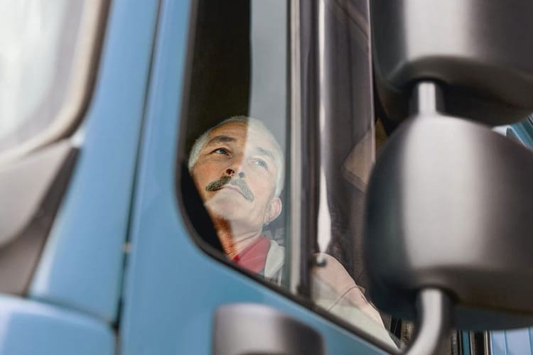 Ein Mann schaut aus einem Lastwagenfenster.