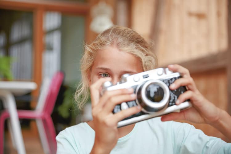 Ein Mädchen mit einer Kamera in der Hand