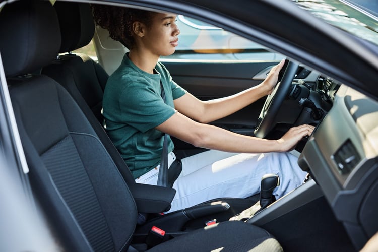 Giovane donna al volante di un’automobile