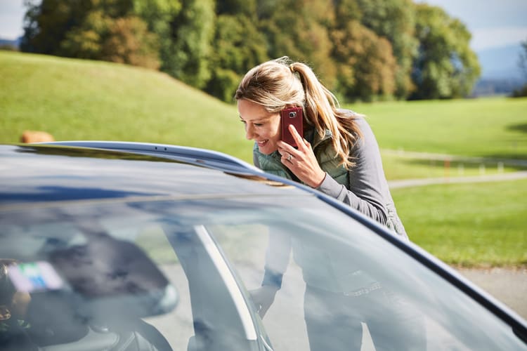 Una donna in macchina al telefono