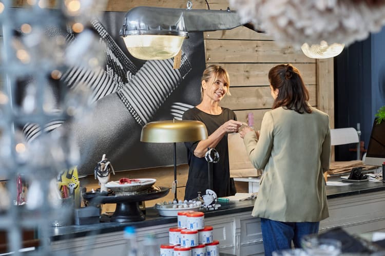Deux femmes discutent à un comptoir.