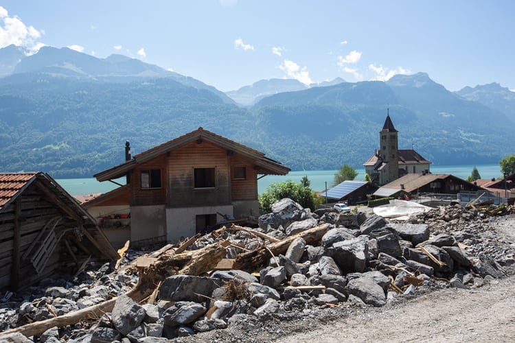 Ein Haus in Brienz, im Hintergrund der See davor ein Geröllhaufen vom Unwetter