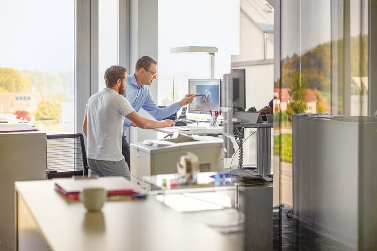 Deux hommes regardent l’écran dans un bureau