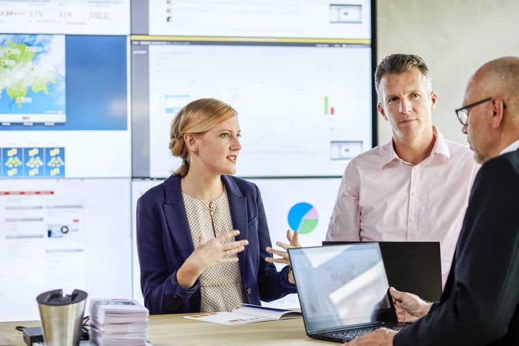 Des personnes discutent d’un thème autour d’une table en bois.