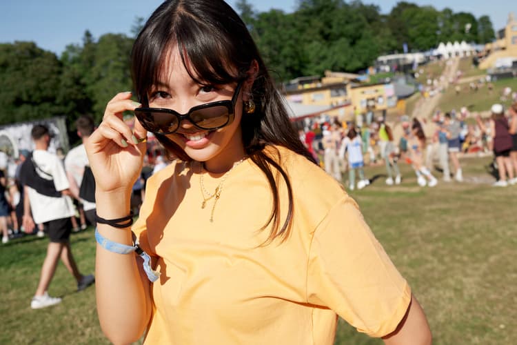 Junge Frau in gelbem T-Shirt an einem Open Air Festival 