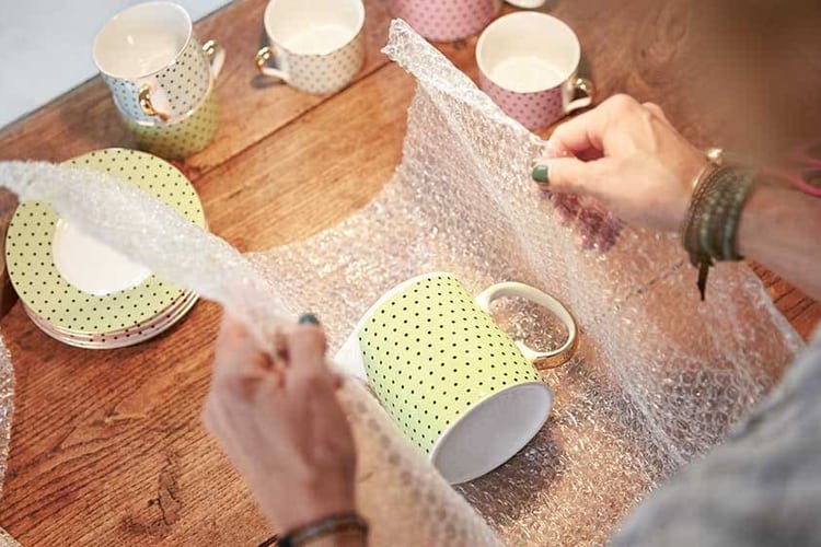 Eine Frau packt eine Tasse ein