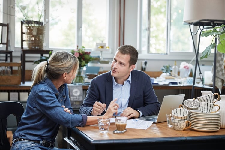 Una donna e un uomo discutono qualcosa al tavolo