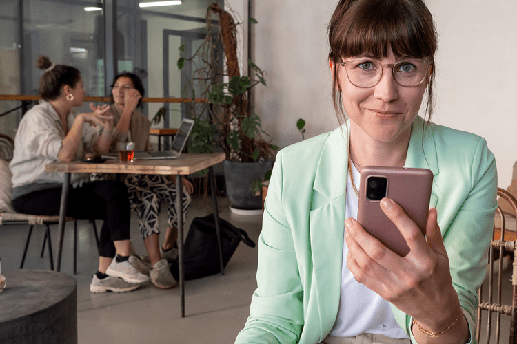 Junger Frau im Kaffee schaut auf ihr Smartphone