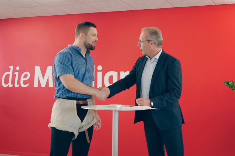 Fabian Staudenmann und ein Mitarbeiter der Agentur Bern-Stadt schütteln die Hände.