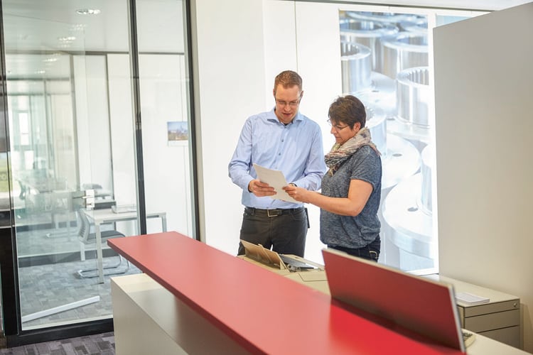 Un homme et une femme discutent dans un bureau.