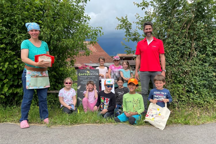 Eine Gruppe Menschen in einem Garten mit einem Insektenhotel