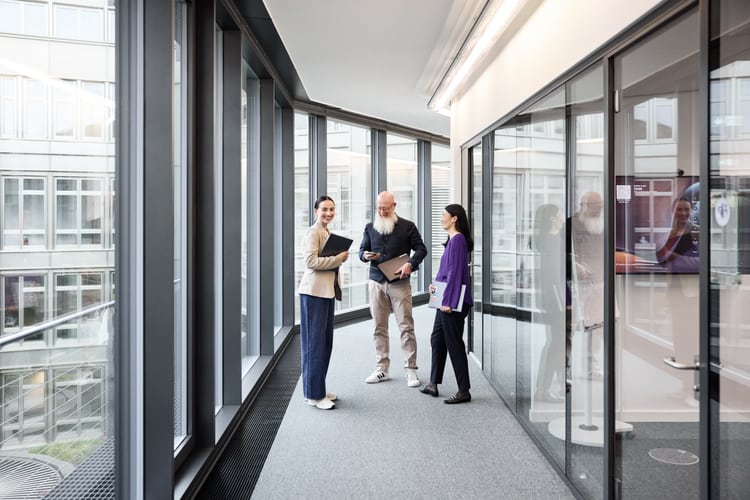 Mitarbeitende treffen sich im Korridor