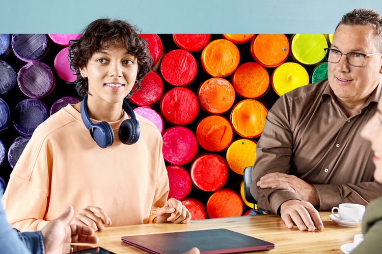 Mitarbeiterin mit Headset diskutiert mit ihren Arbeitskollegen