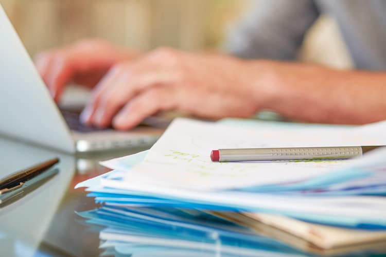 Person tippt auf einem Laptop