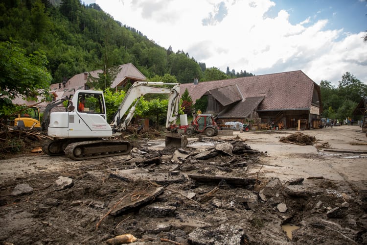 Bagger arbeitet sich durch das verwüstete Hotelareal Kemmeriboden-Bad nach dem Unwetter im Juli 2024