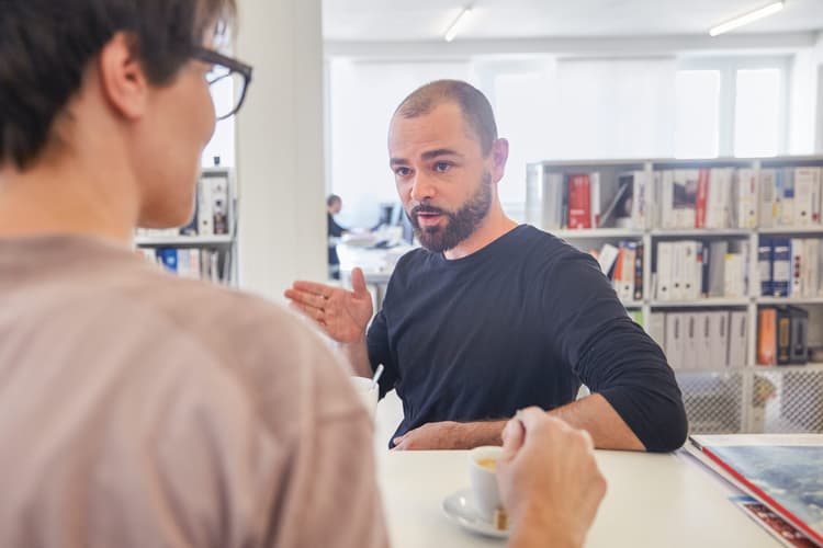 Un homme et une femme discutent à un bureau.
