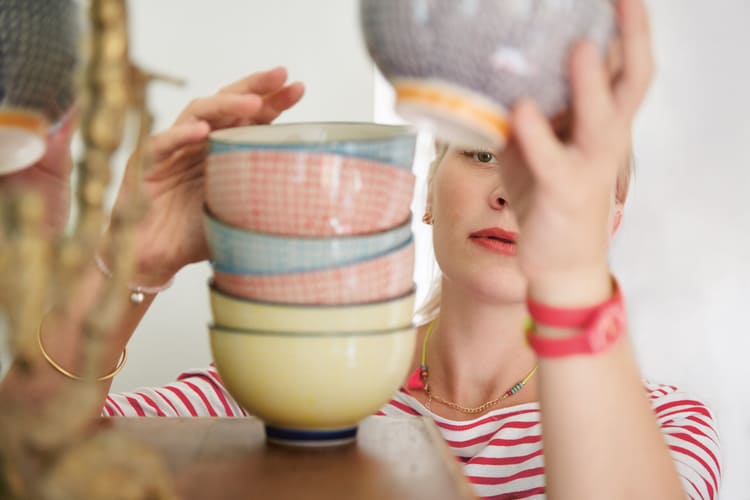 Eine Frau stapelt das Geschirr