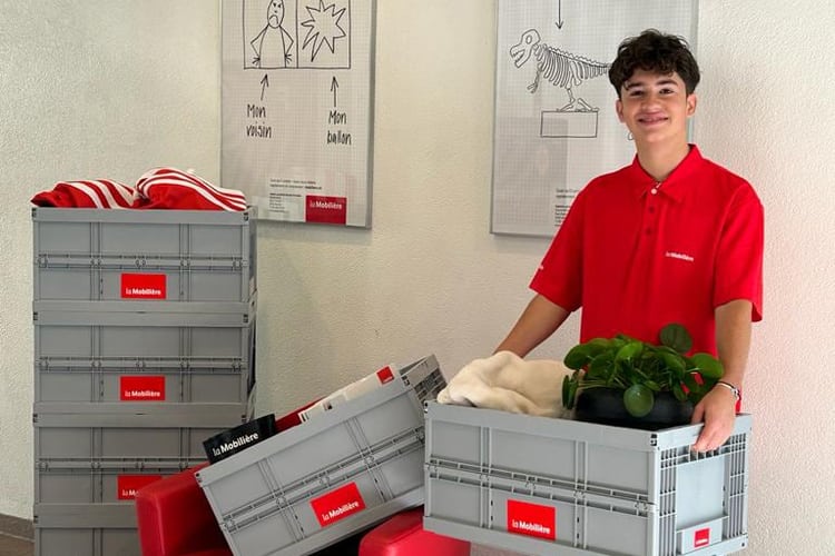 Un jeune homme tient les cartons de déménagement de la Mobilière dans les mains.