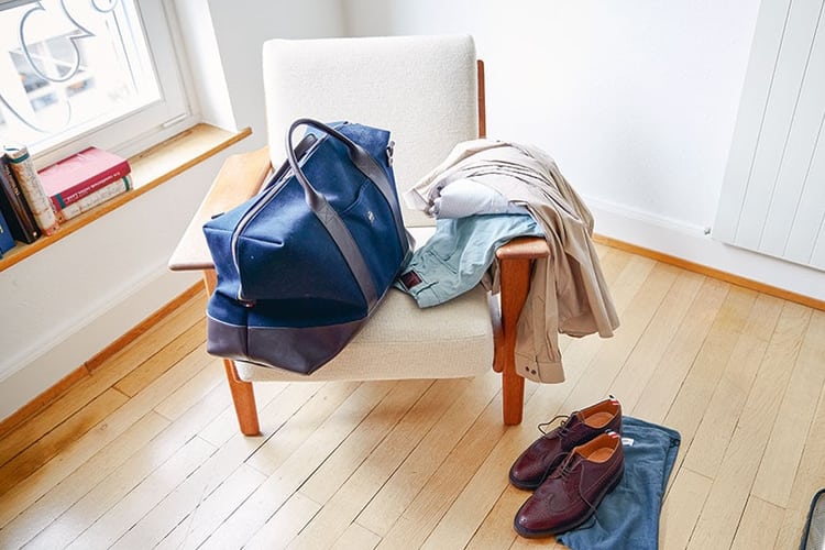 Kleider und eine Tasche auf einem Sessel