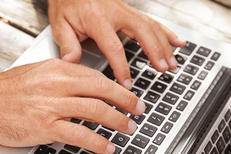 Hände auf einem Laptop