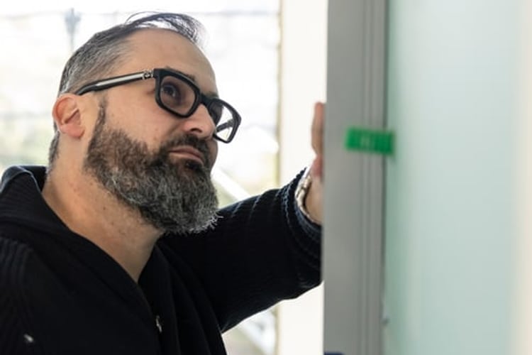 C’è un uomo che tiene una livella appesa al muro.