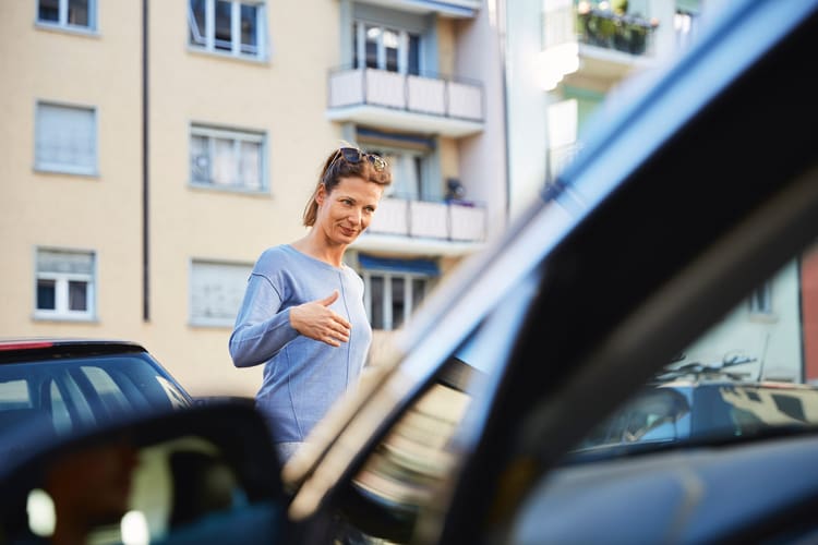 Una donna davanti a un’auto parcheggiata