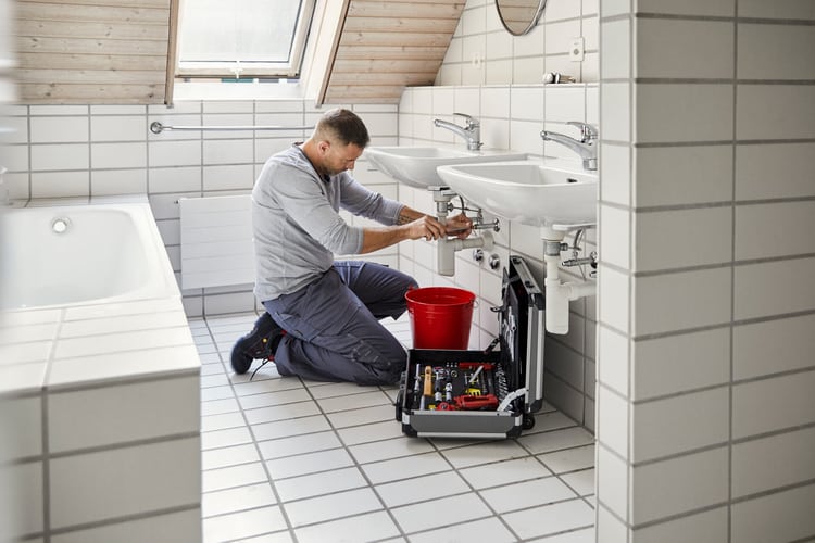 sanitaer-repariert-abfluss-im-badezimmer