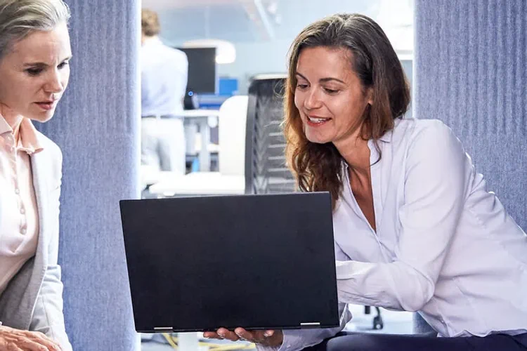 Zwei Frauen schauen auf einen Laptop