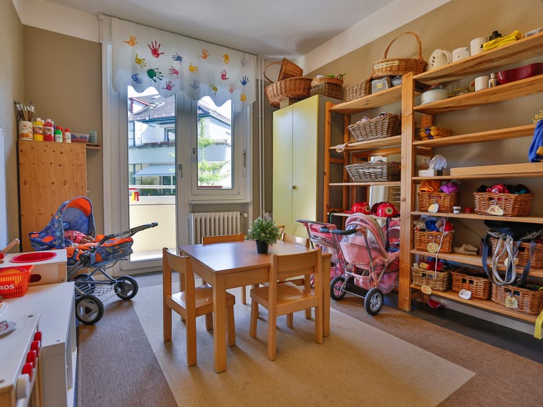 Ein Spielzimmer mit einer Spielküche und Esstisch