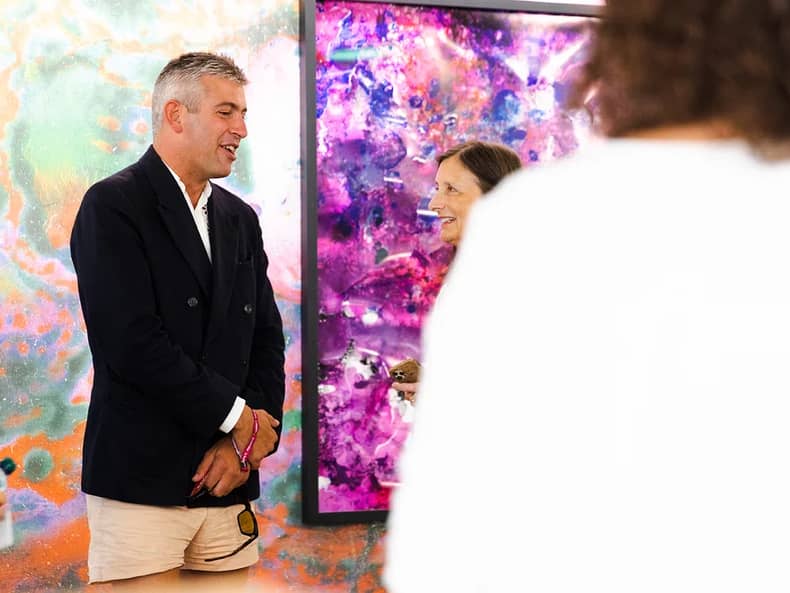 Un uomo davanti a un dipinto nella mostra Arte e sostenibilità presso la Mobiliare 