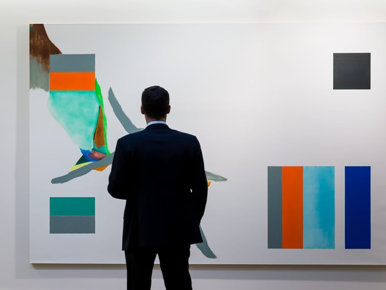 Mann vor abstraktem Kunstwerk in der Ausstellung Kunst und Nachhaltigkeit in der Mobiliar
